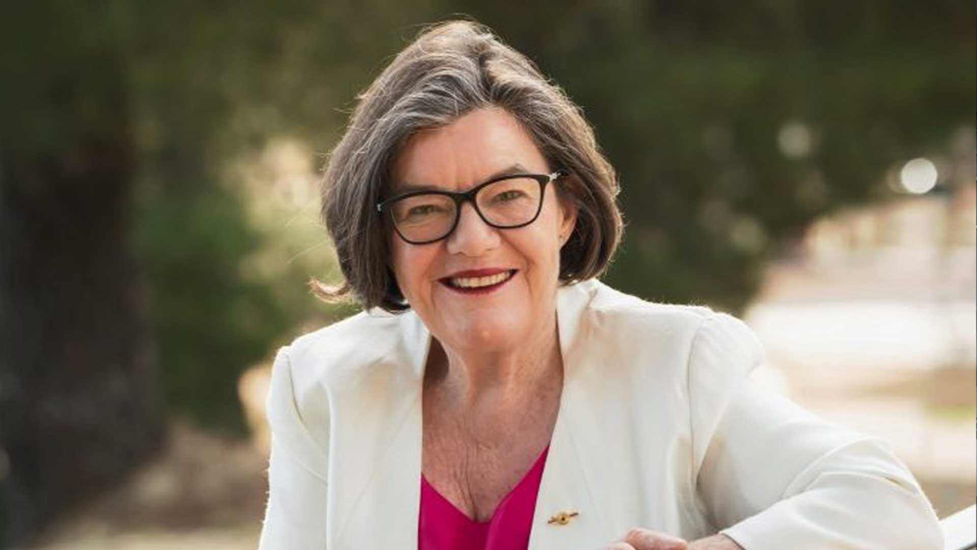 Cathy McGowan wearing a white jacket and smiling