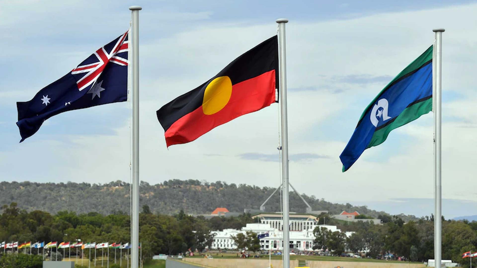 Australian, Indigenous and Torres Strait Island flags waving in front of Parliament House