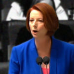 Photo of Julia Gillard wearing blue blazer, delivering the "misogyny speech" in Parliament