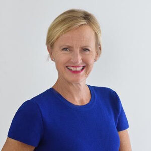 Photo of Katie Allen smiling wearing an electric blue short sleeved top. she has short blonde hair.