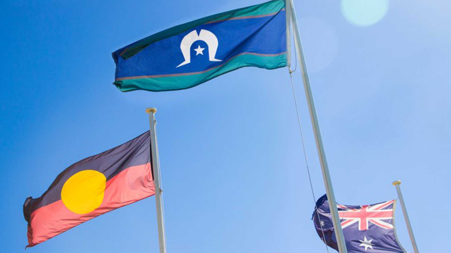 Aboriginal, Torres Strait Islands and Australian flags against a blue sky