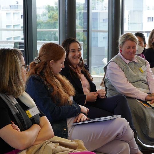 Row of women seated lecture style, laughing