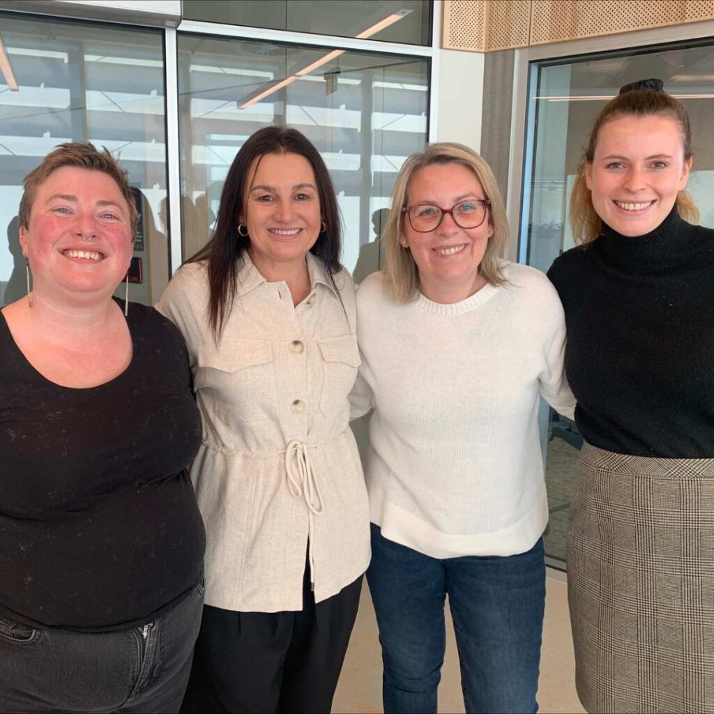 Photo of Jacqui Lambie smiling with her arms around 3 other women