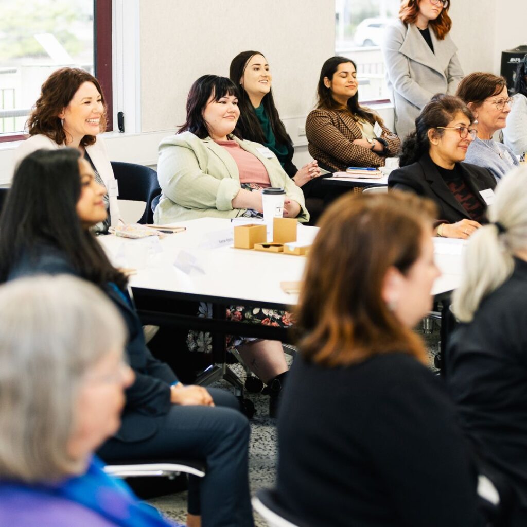 Group of diverse women seated around tables smiling