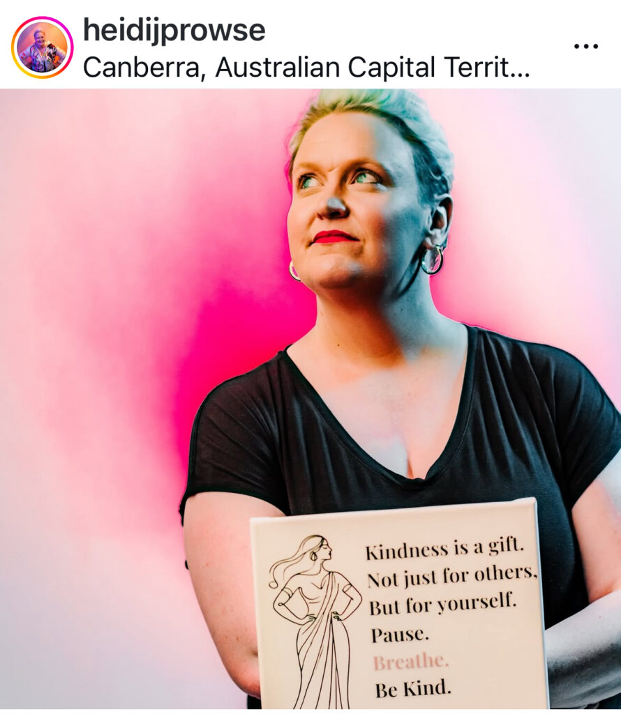 Photo of Heidi Prowse looking upwards, against a bright pink background.