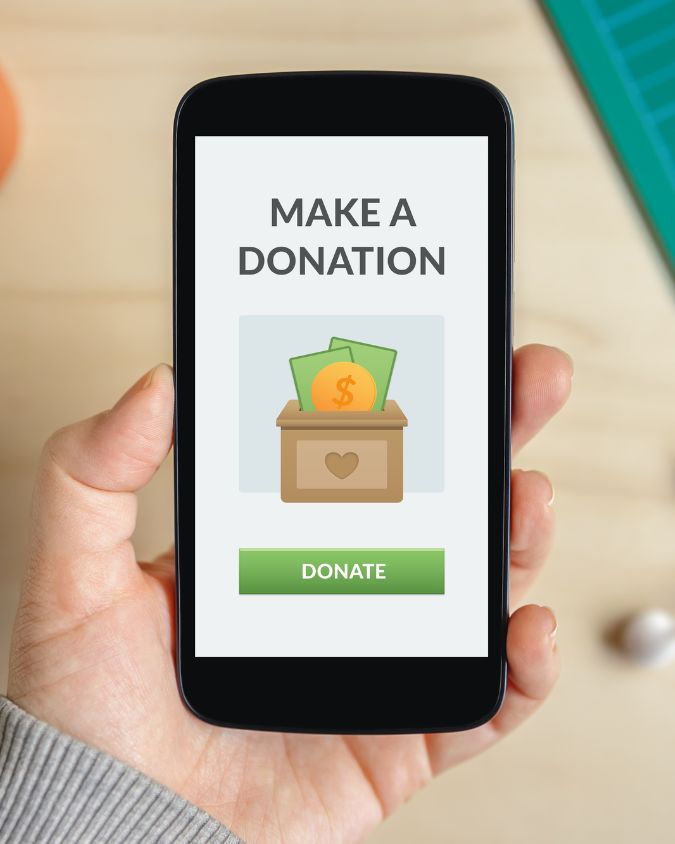 close up of a smart phone displaying an app with the text "make a donation"