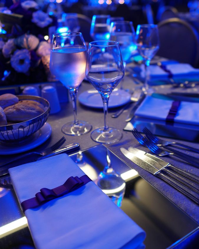 Close up of a glass of white wine and nicely set dining table