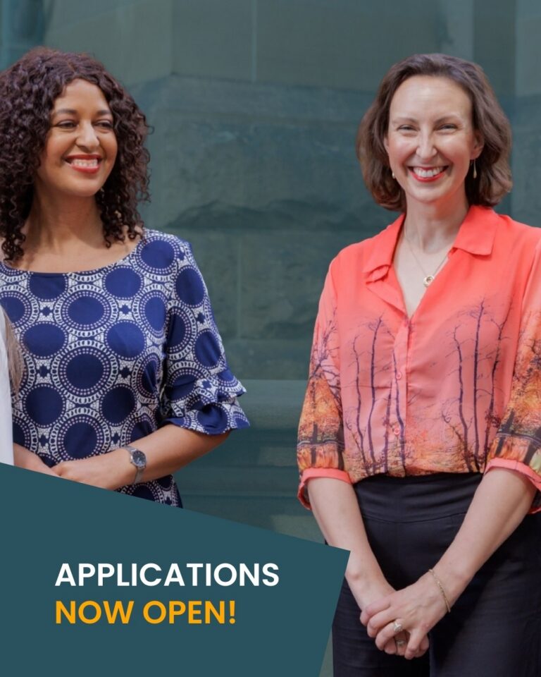 Photo of two smiling women standing in front of stone wall, words overlaid in a rectangle below: Applications now open!