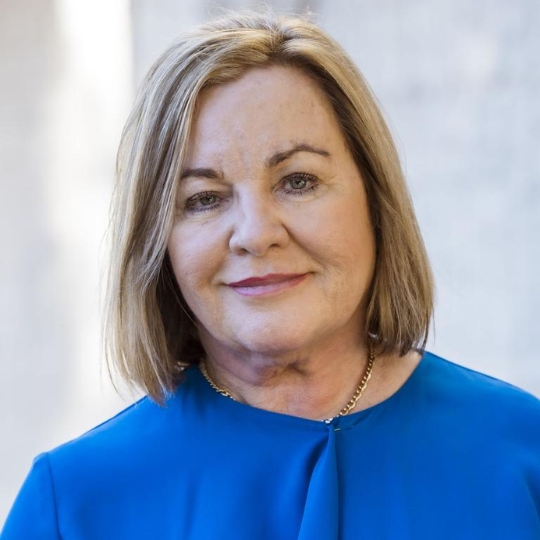 Headshot of Dr Keri Spooner wearing a bright blue blouse